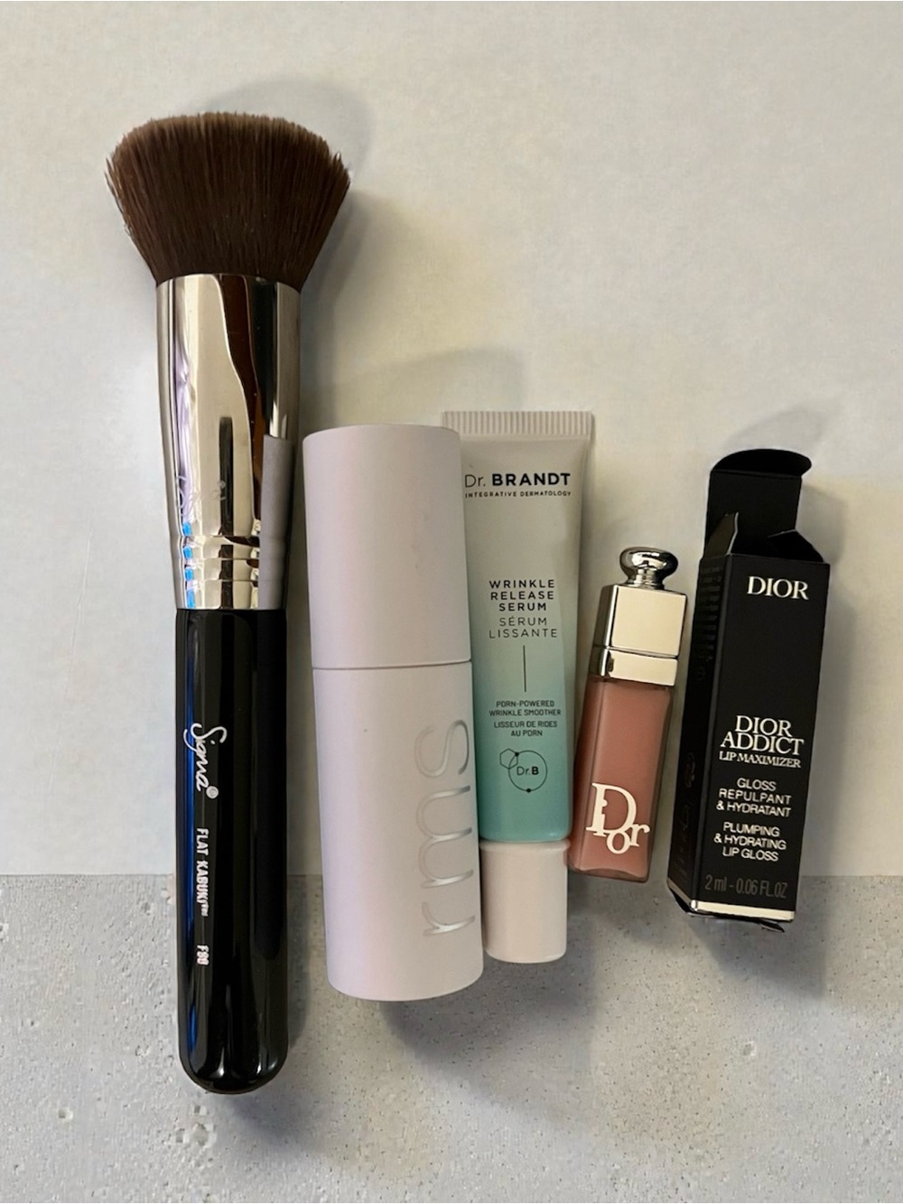 Sigma flat kabuki F80, RMS beauty lipgloss, Dr. Brand serum, Lip Maximizer Gloss